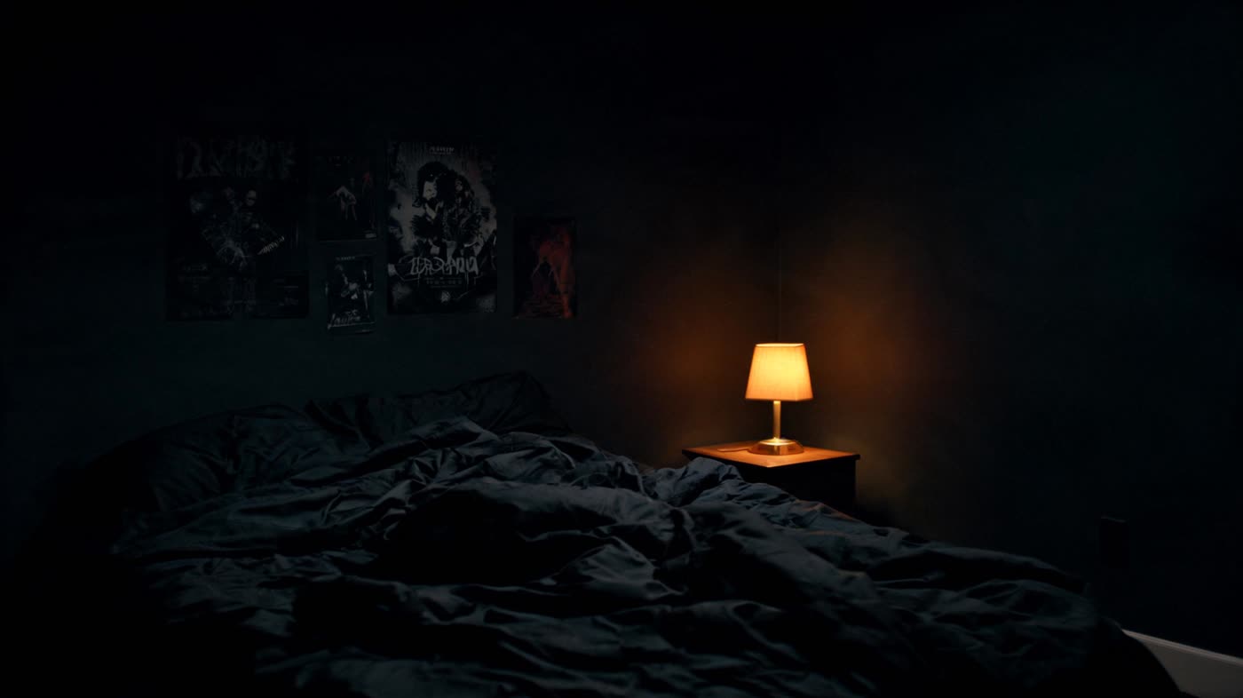 Cozy bedroom with warm lamp light glowing in the dark